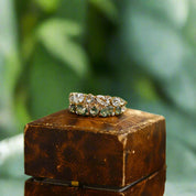 Gold ring with diamonds on a wooden block against a blurred background