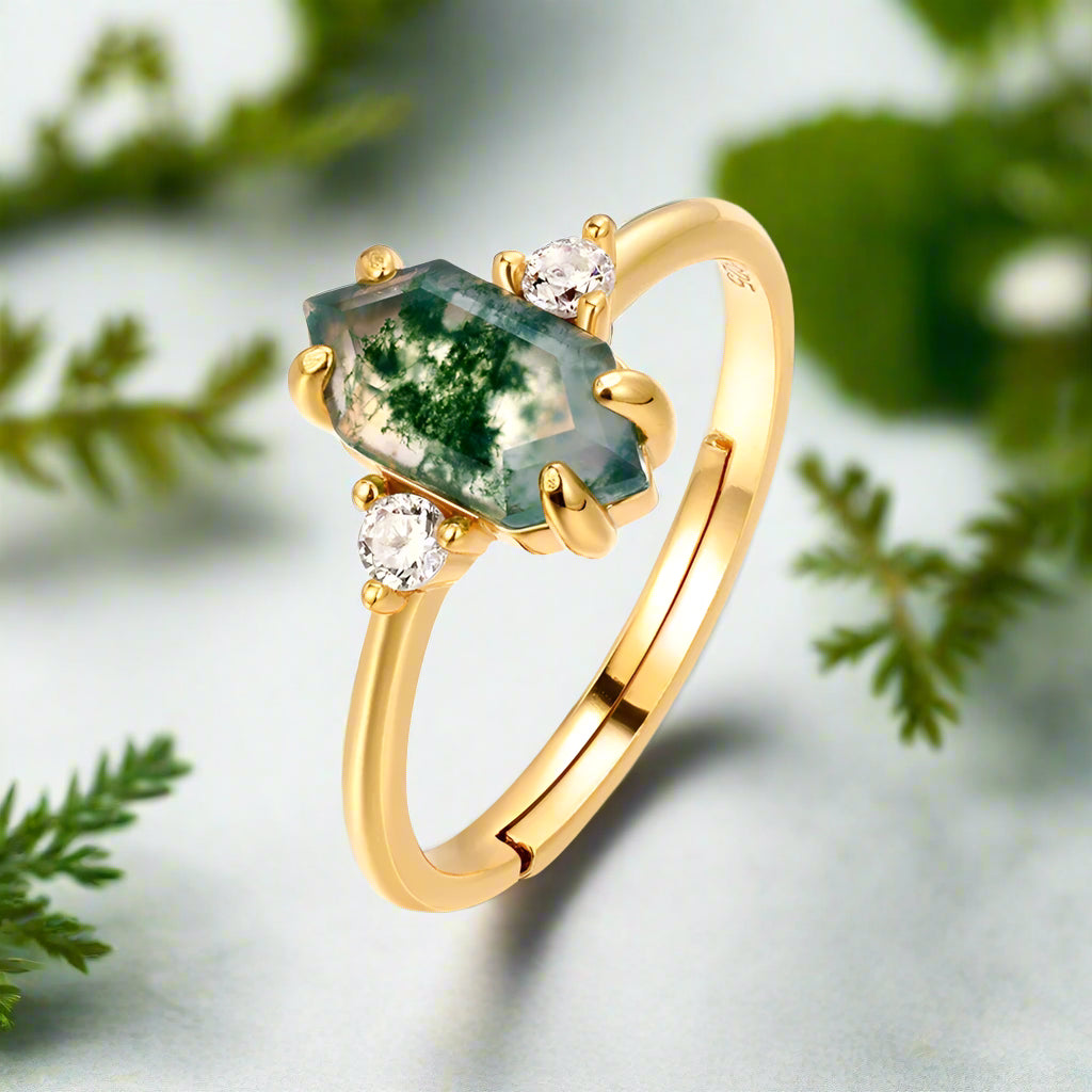 Gold ring with green gemstone and diamonds on a white background