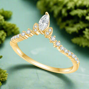 Gold ring with pear-shaped diamond and smaller diamonds on a white background