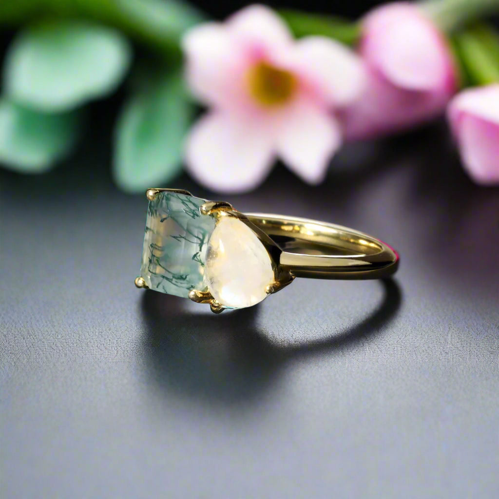 Gold ring with two large gemstones on a dark surface