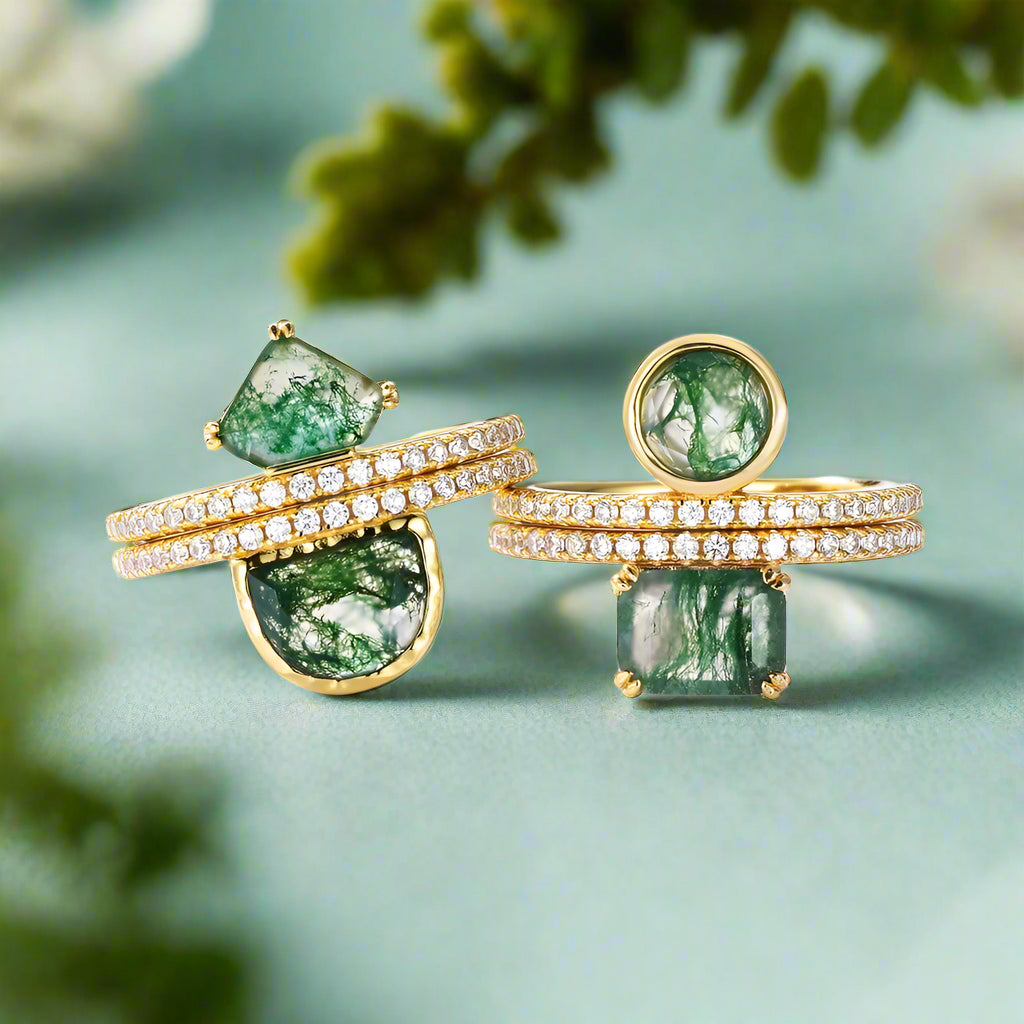 Gold rings with green gemstones on a white background