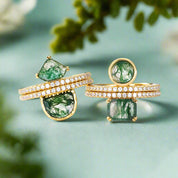 Gold rings with green gemstones on a white background