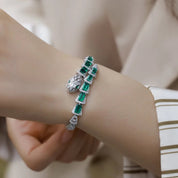 Green gemstone bracelet on a wrist with a blurred background