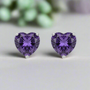Heart-shaped purple gemstone earrings on a white background