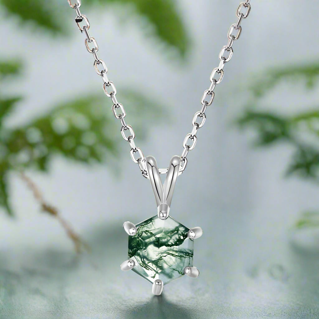 Hexagonal green stone pendant on a silver chain against a white background