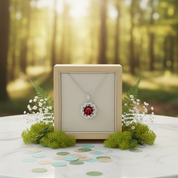 Jewelry box with a necklace featuring a red gemstone in a forest setting
