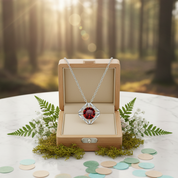 Jewelry box with a necklace featuring a red gemstone, set against a forest background.