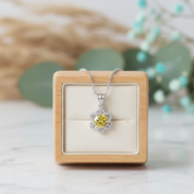 Jewelry box with a necklace featuring a yellow gemstone pendant on a light background