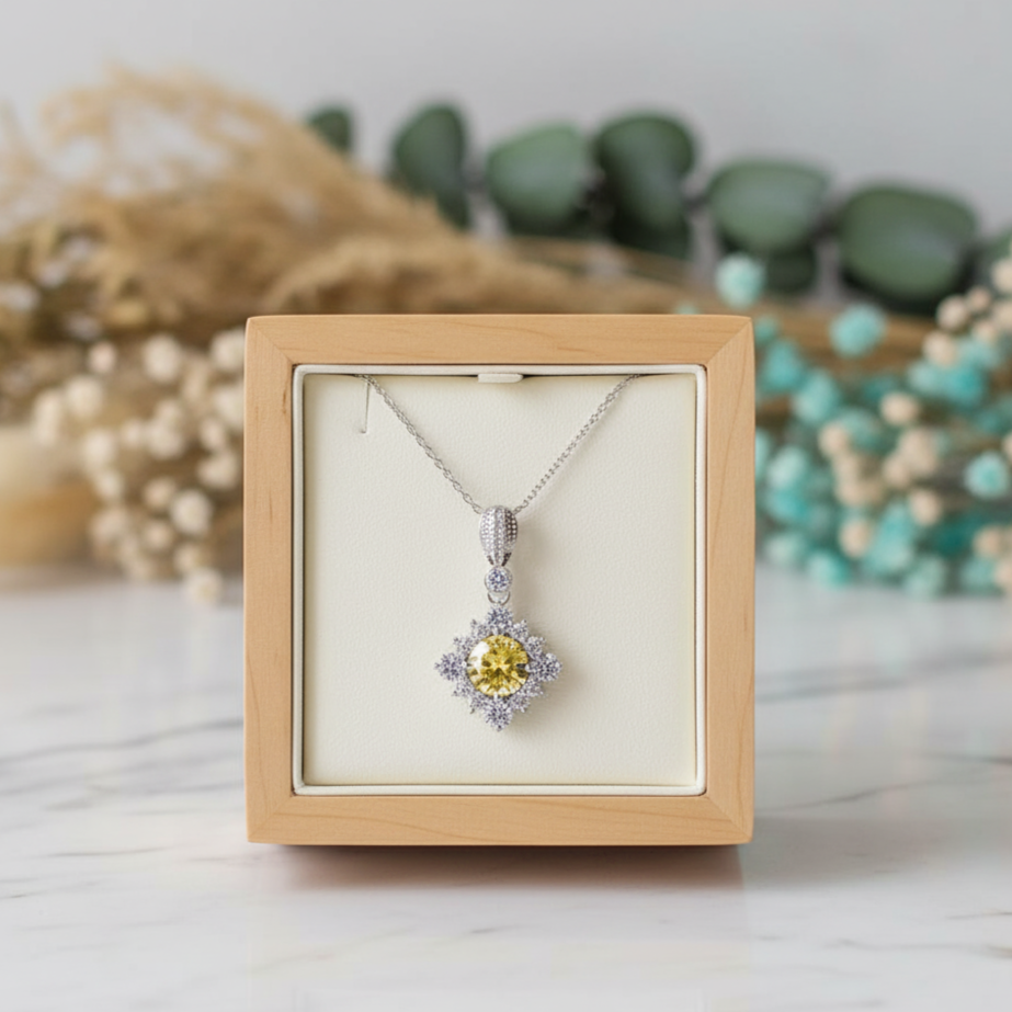 Jewelry box with a yellow gemstone pendant on a light background