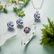 Jewelry set with ring, earrings, and necklace featuring purple gemstones on a white background