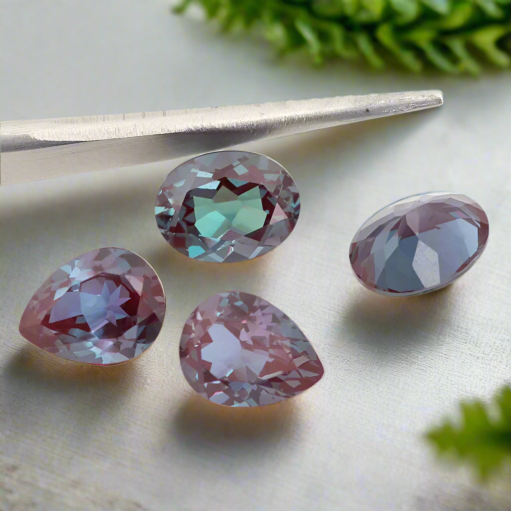 Multicolored gemstones with tweezers on a white background