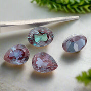 Multicolored gemstones with tweezers on a white background