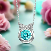 Necklace with a blue gem and bow design against a floral background