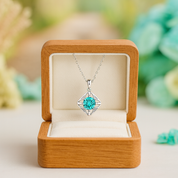 Necklace with a turquoise pendant in an open wooden box on a blurred natural background