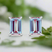 Pair of emerald-cut gemstone earrings on a white background