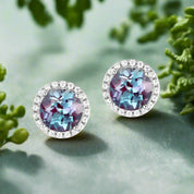 Pair of round earrings with multicolored gemstones on a white background