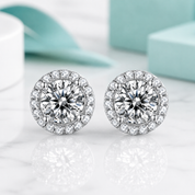 Pair of silver earrings with clear gemstones on a light background