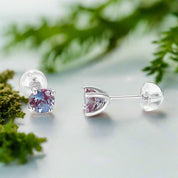 Pair of silver earrings with gemstones on a light gray background