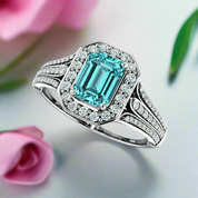 Ring with a blue gemstone and diamond-studded band on a white background