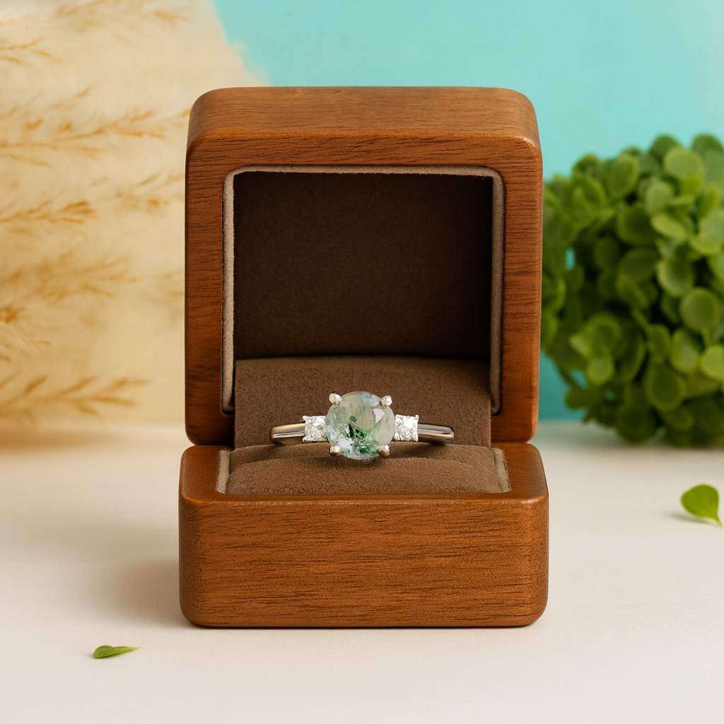 Ring with a green gemstone in a wooden box on a light background