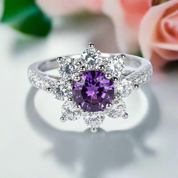 Ring with a purple gemstone and diamond-like stones on a white background