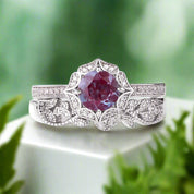 Ring with a purple gemstone and diamond-studded band on a light gray background