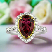 Ring with a red gemstone and diamond accents on a floral background