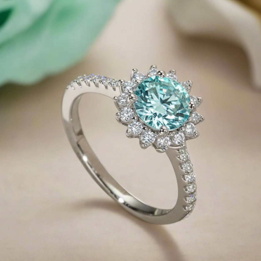 Ring with a turquoise gemstone and diamond-studded halo on a beige surface.