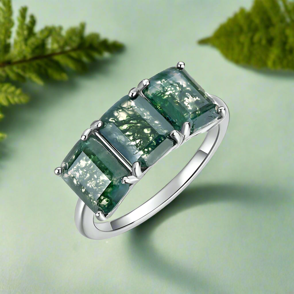 Ring with green gemstones on a white background