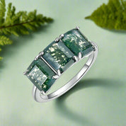 Ring with green gemstones on a white background