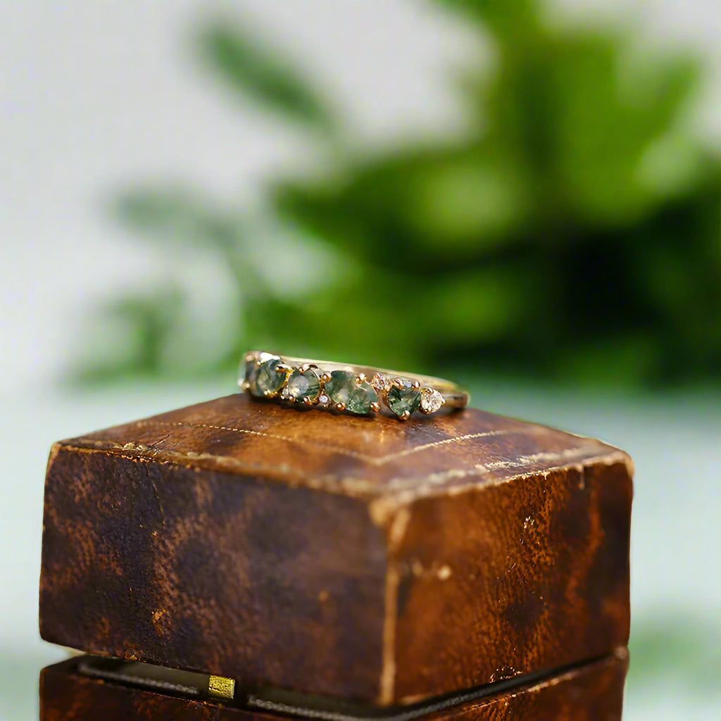 Ring with green gemstones on a wooden box with a blurred background
