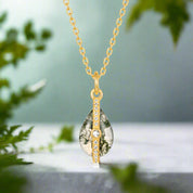 Gold necklace with a teardrop-shaped pendant on a white background