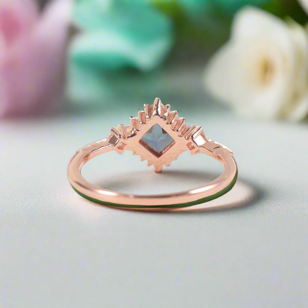 Rose gold ring with a blue gemstone on a white background
