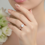 Rose gold ring with a central gemstone on a light green surface