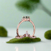 Rose gold ring with green gemstone on a dark background