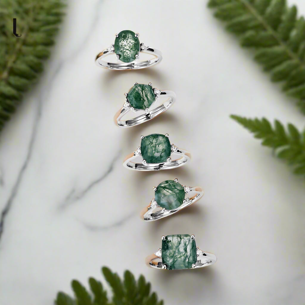 Set of five silver rings with green gemstones on a white background