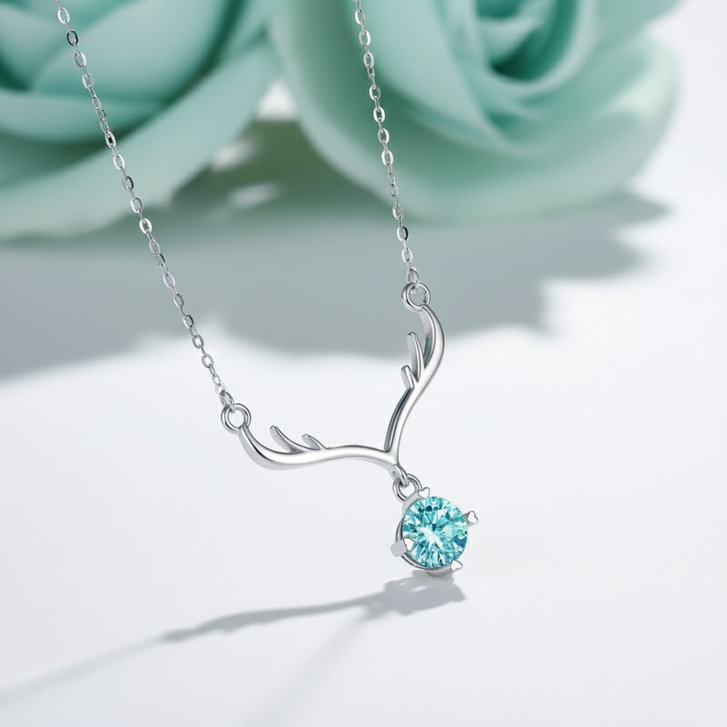 Silver antler-shaped necklace with a blue gemstone on a blue background