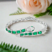 Silver bracelet with green gemstones on a white background