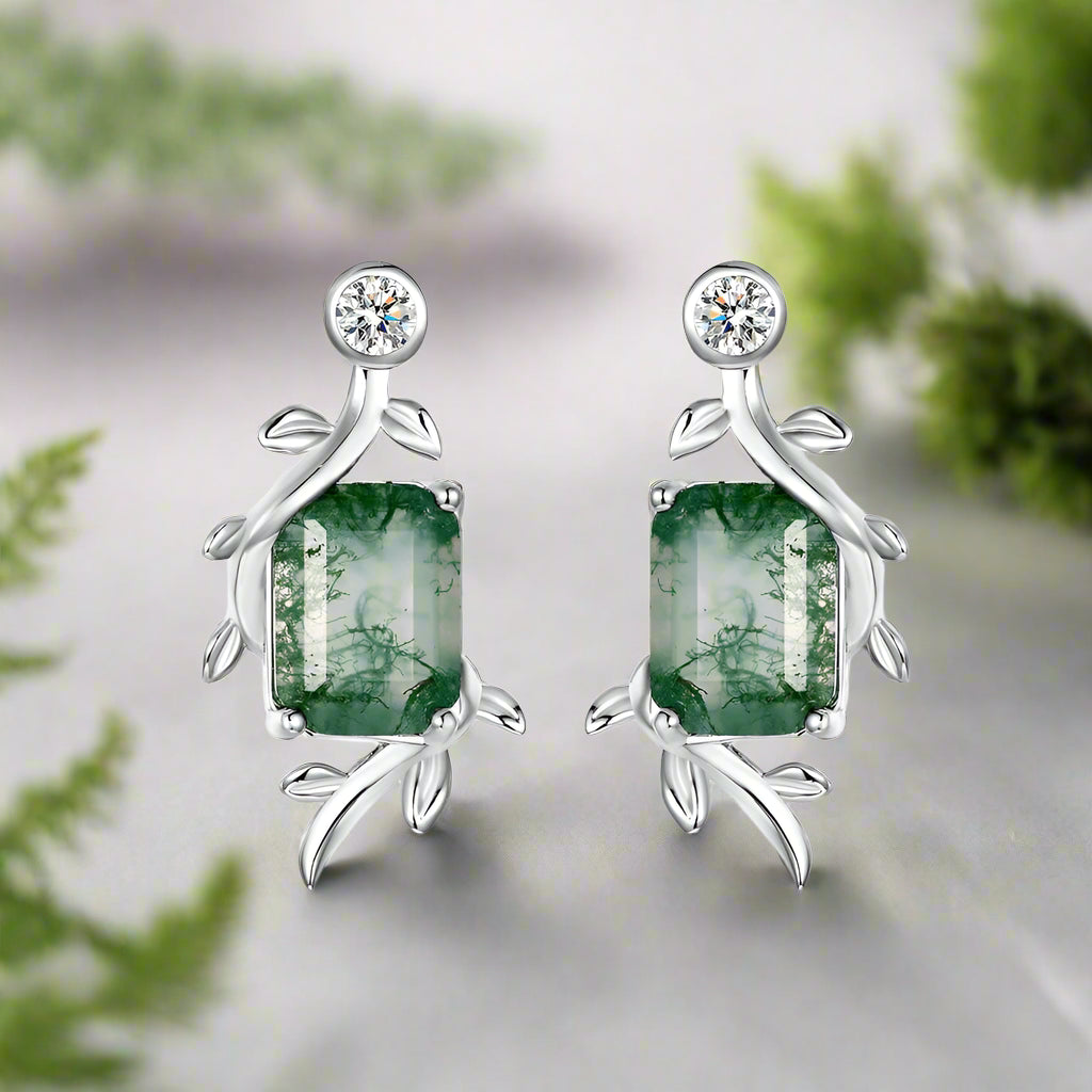 Silver earrings with green gemstones on a white background