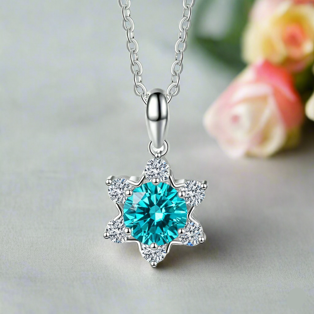 Silver necklace with a blue gemstone pendant on a light gray background