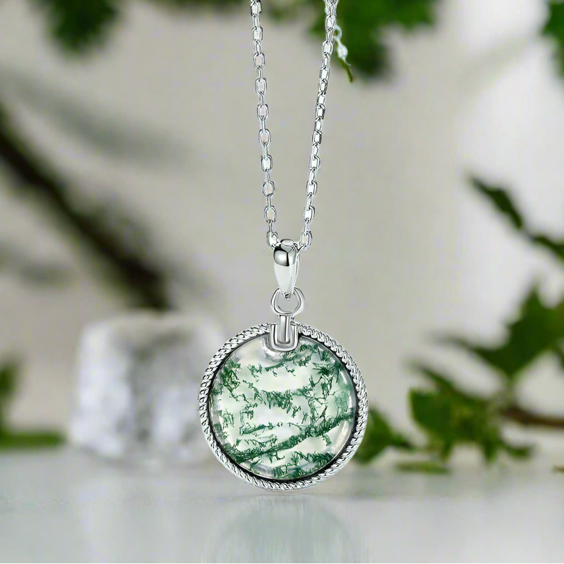 Silver necklace with a green marbled pendant on a light blue background