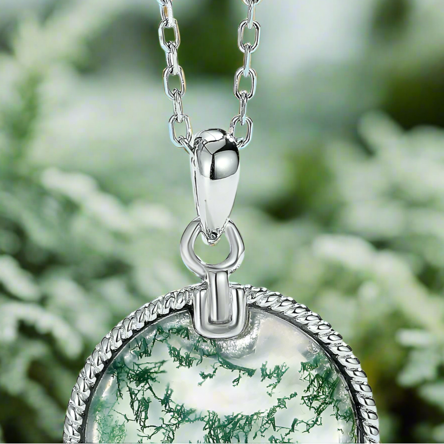 Silver necklace with a green pendant on a light blue background