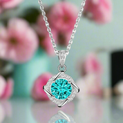 Silver necklace with a turquoise pendant against a blurred floral background