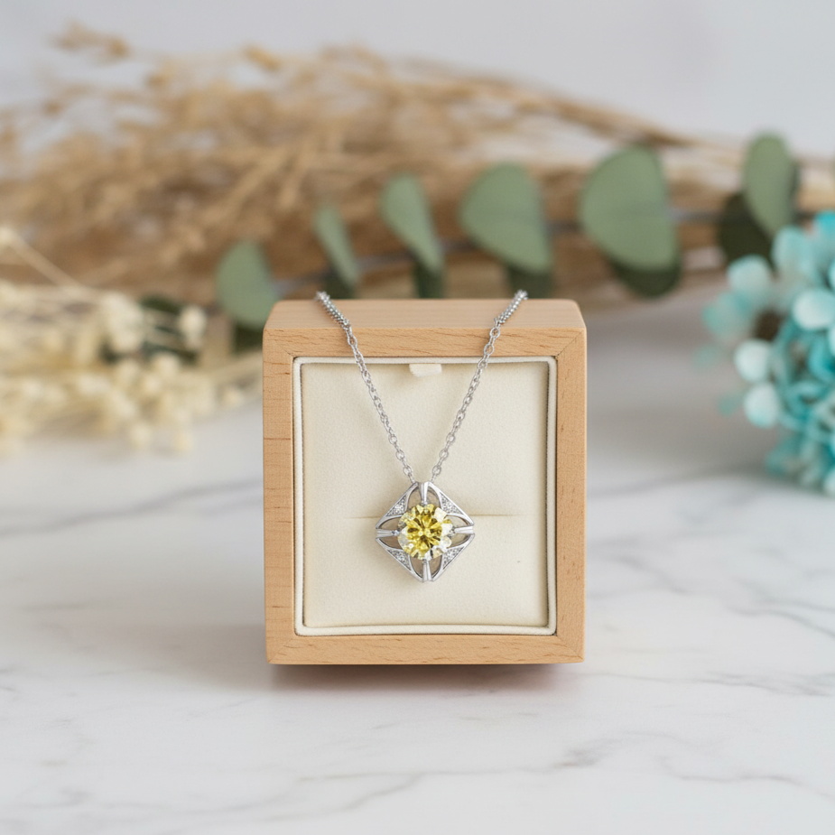 Silver necklace with a yellow gemstone in a wooden box on a light background
