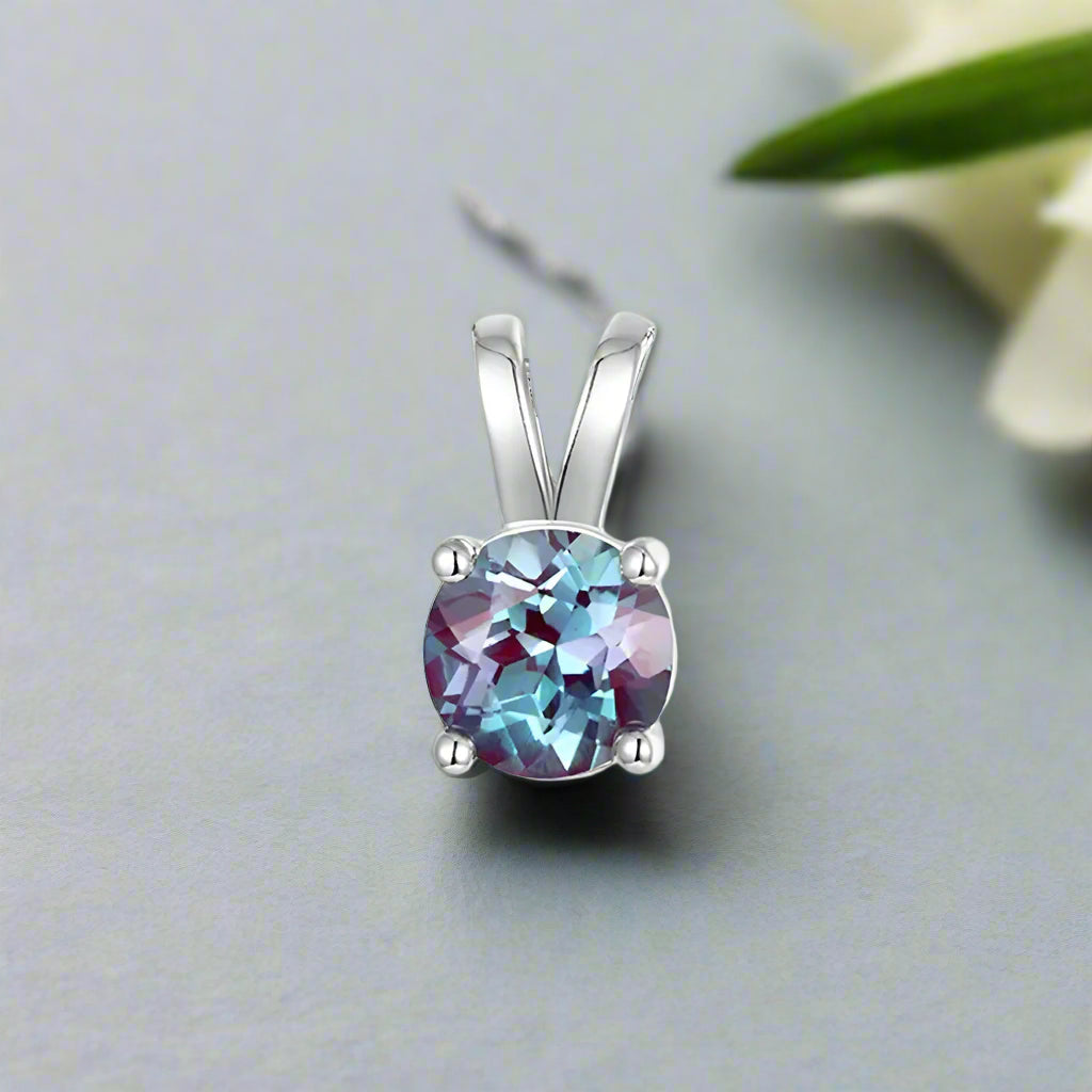 Silver pendant with a colorful gemstone on a white background