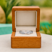 Silver ring in a wooden box with a blurred natural background