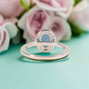 Silver ring with a blue gemstone on a white background