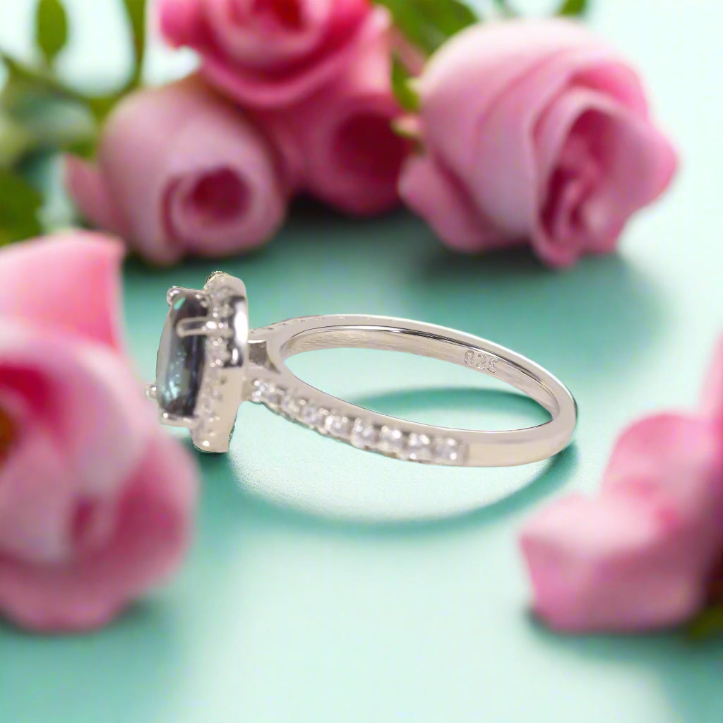 Silver ring with a blue gemstone on a white background