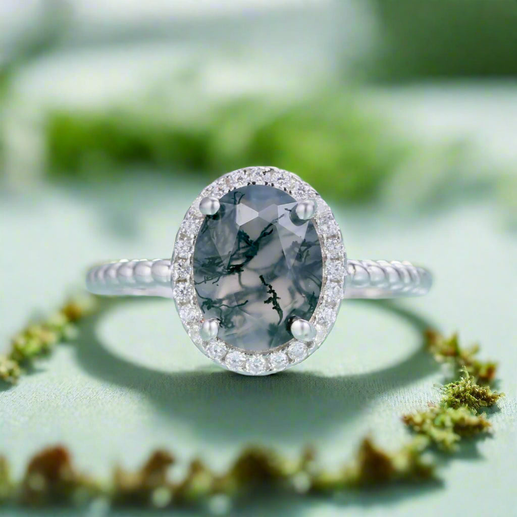 Silver ring with a gray gemstone on a light blue background