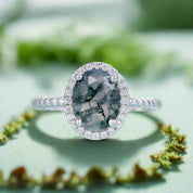 Silver ring with a gray gemstone on a light blue background